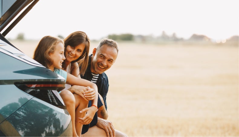 Family sitting in the trunk of a SUV